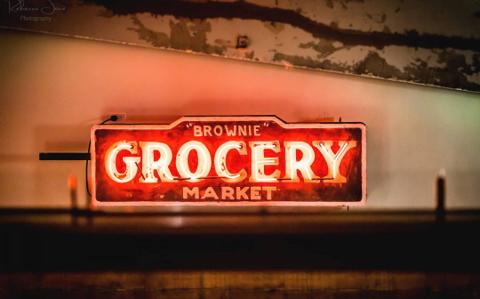 The vintage neon 'Brownie Grocery Market' sign, part of the venue's curated decor
