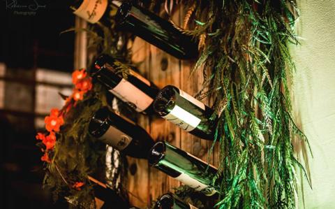 Wine bottle and greenery wall detail near the bar
