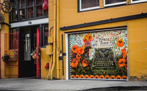 The Press Room's street-level entrance and hand-painted mural on Opera Alley