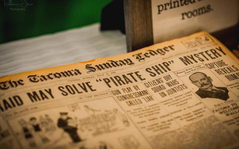 A framed reproduction of the Tacoma Sunday Ledger, a nod to the building's print-shop history