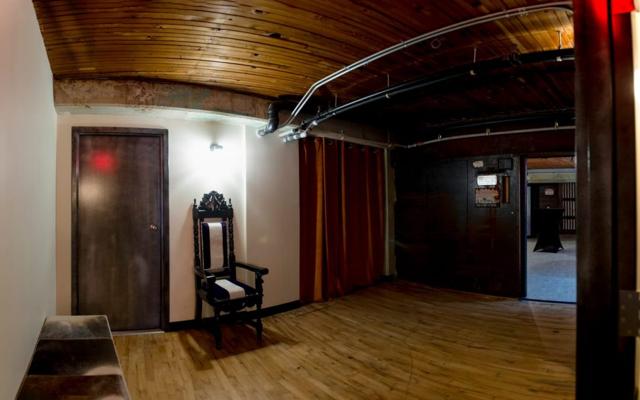 A quiet anteroom near the entrance, with reclaimed wood ceiling and an antique chair