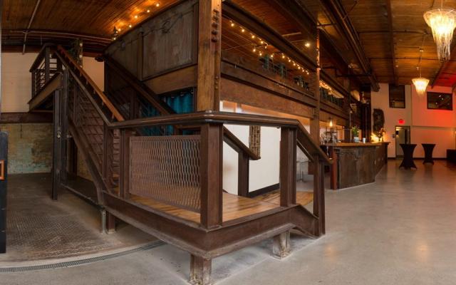 Reclaimed I-beam and hardwood grand staircase inside The Press Room